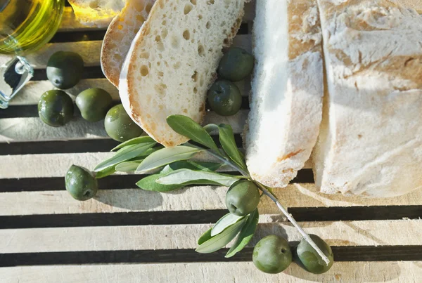 Italy, Tuscany, Magliano, Close up of bread, olives and olive oil on chopping board, elevated view — Stock Photo, Image