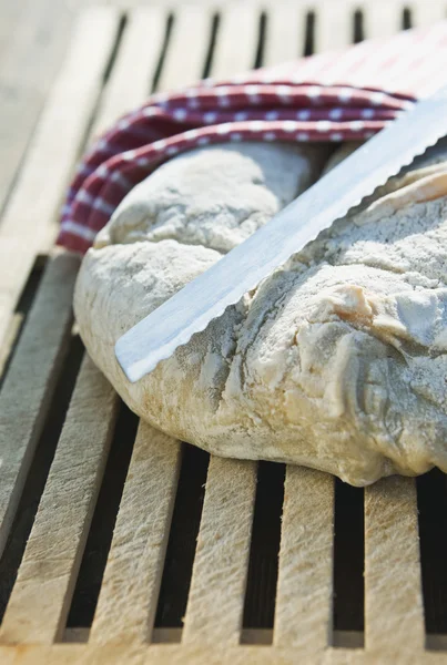 Italy, Tuscany, Magliano, Close up of bread and knife on wooden table — Stockfoto