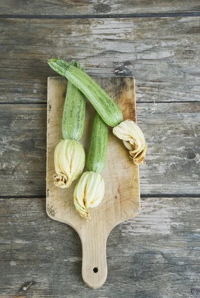 Italy, Tuscany, Magliano, Zucchini with flowers on cutting board — Zdjęcie stockowe