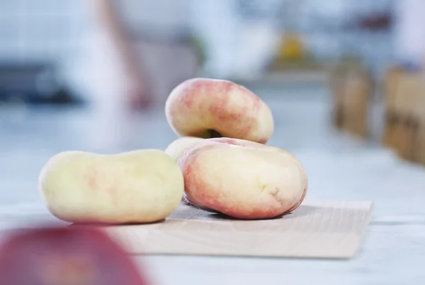 Italy, Tuscany, Magliano, Close up of flat peaches on chopping board — Stockfoto