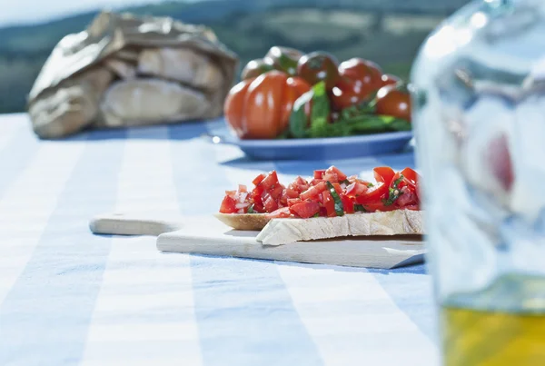 Italy, Tuscany, Magliano, Bruschetta, bread, tomatoes and olive oil on table — Stockfoto