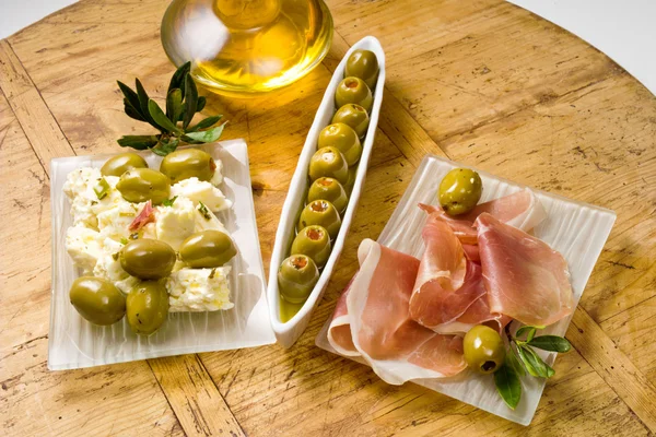 Tapas, zelené olivy, parmská šunka — Stock fotografie