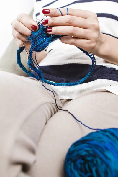 Young woman knitting blue scarf — Stock Photo, Image
