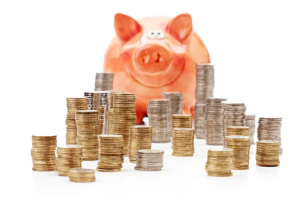 Piggy bank met stapels van euro-muntstukken — Stockfoto
