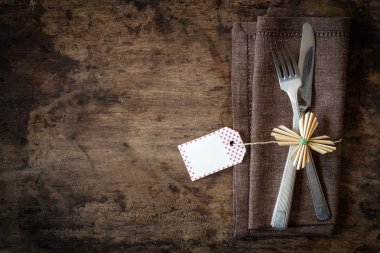 Çatal bıçak takımı kahverengi peçete üzerinde dekore edilmiş