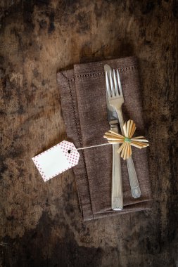 Çatal bıçak takımı kahverengi peçete üzerinde dekore edilmiş