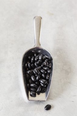 Metal kaşık siyah fasulye yığını