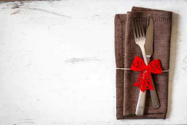 Decorated cutlery on brown napkin — Stock Photo, Image
