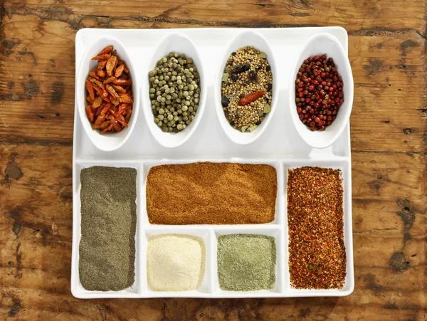 Different spices in bowls and on plate — Stock Photo, Image