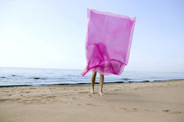Frau versteckt sich hinter rosa Tuch — Stockfoto