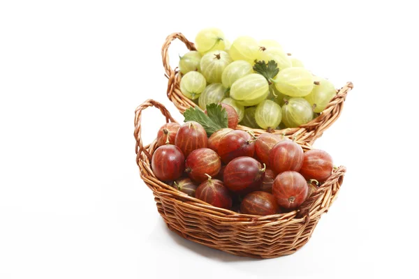 Red and green gooseberries in wooden baskets — Stock Photo, Image