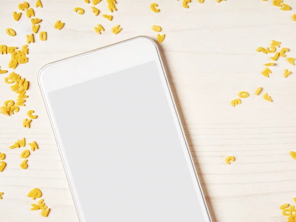 Smartphone with alphabet noodles — Stock Photo, Image