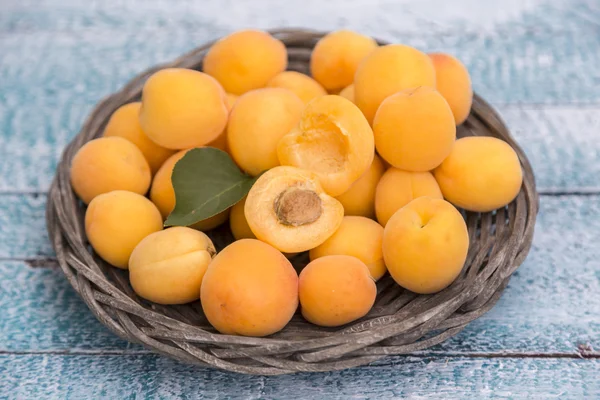 Fresh apricots in straw plate — Stock Photo, Image