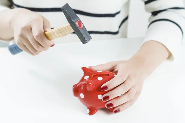Vrouw smashing piggy bank — Stockfoto
