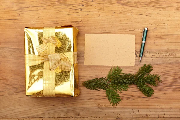Золотий різдвяний подарунок і порожня листівка — стокове фото