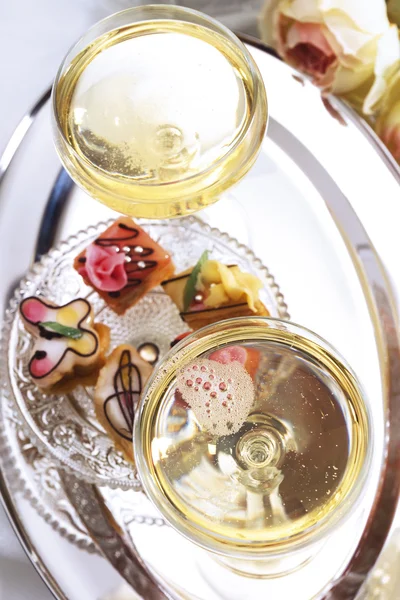 Champagne glasses with pastries — Stock Photo, Image