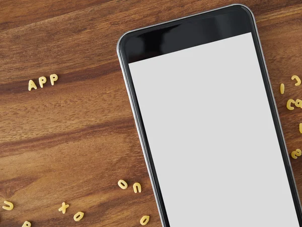 Smartphone en madera, fideos de alfabeto — Foto de Stock