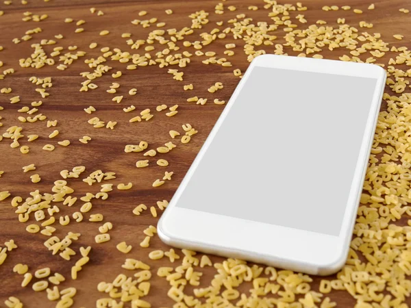 Smartphone en madera, fideos de alfabeto — Foto de Stock