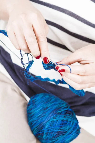 Young woman knitting blue scarf — Stock Photo, Image