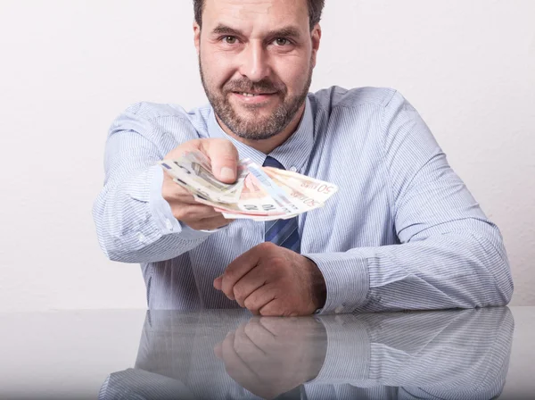 Hombre maduro ofreciendo billetes en euros abanicados —  Fotos de Stock