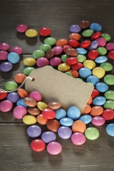 Smarties en madera, tarjeta en blanco —  Fotos de Stock