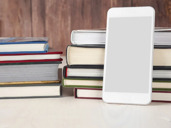 Smartphone and stacks of books Stock Photo
