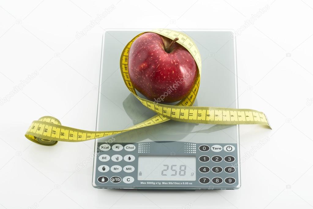 Fresh red apple with measuring tape