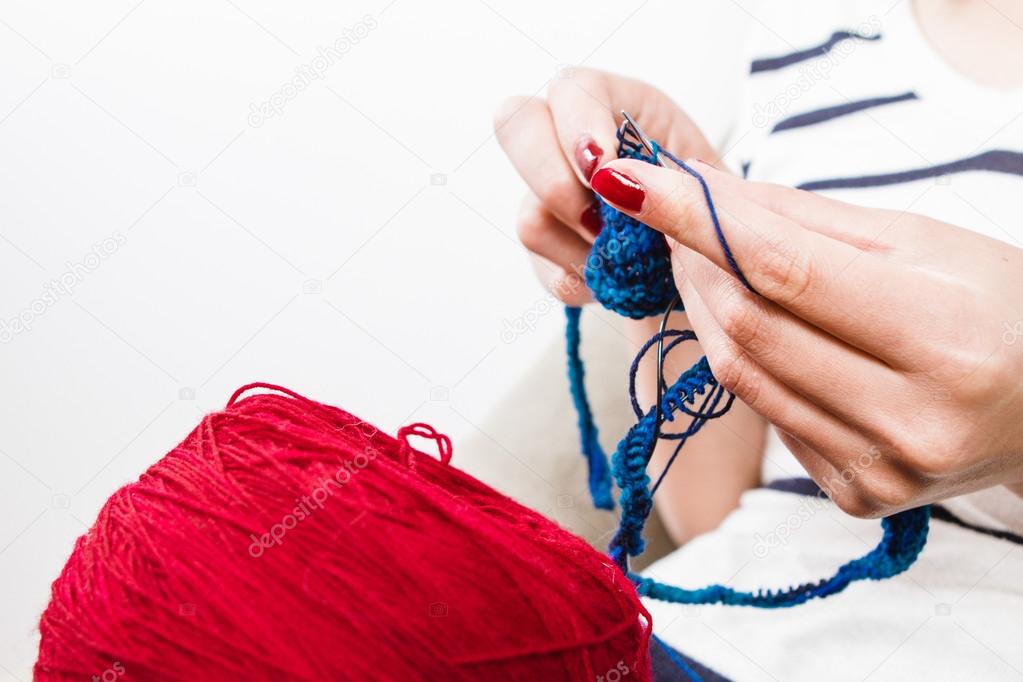 Woman knitting blue scarf