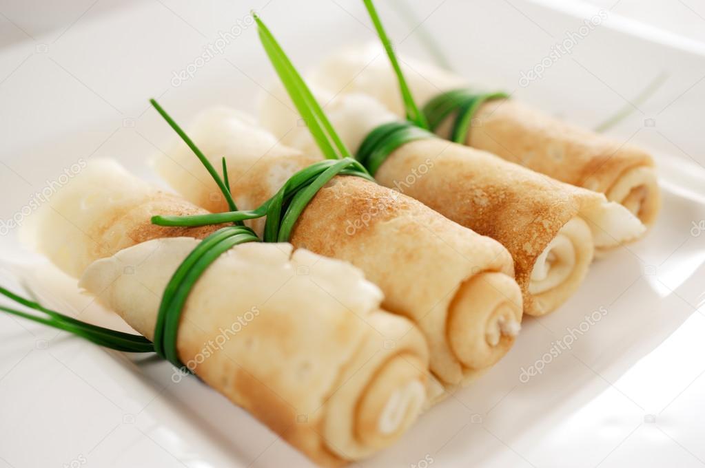 Crepes rolled up and wrapped with chives