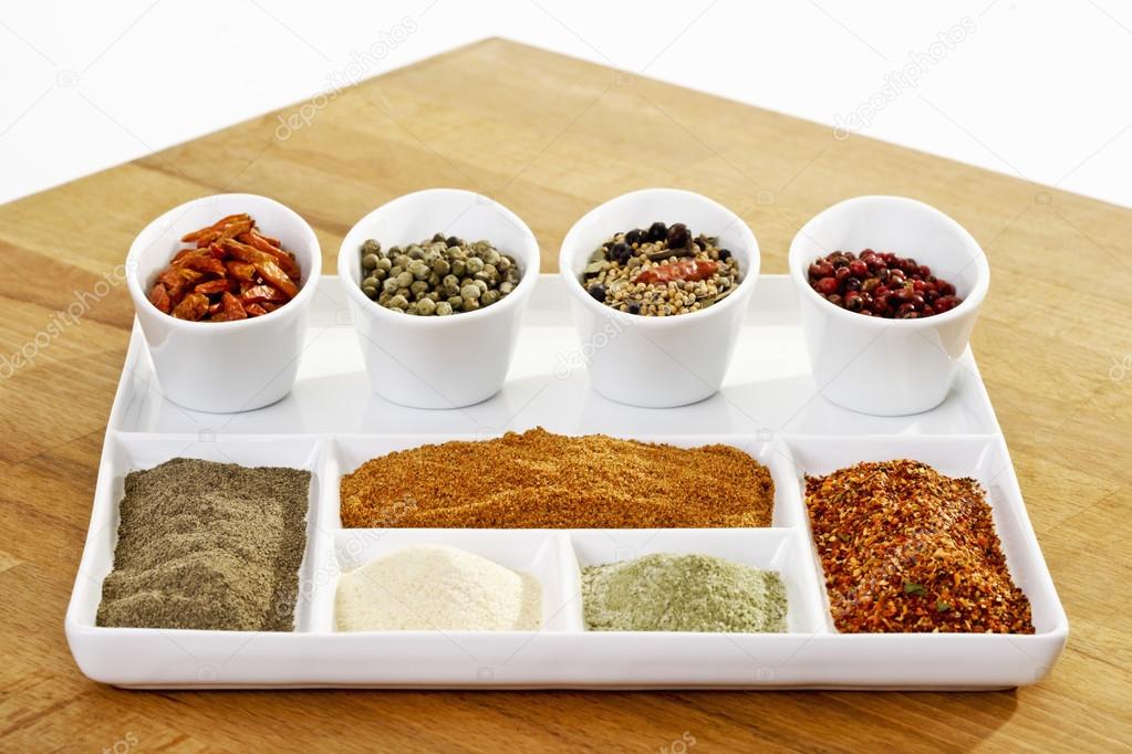 Different spices in bowls and plate