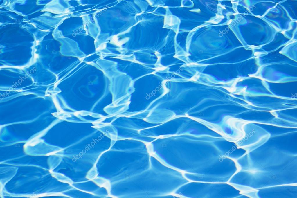 Light Blue swimming pool rippled water texture reflection. Beautiful blue  water background with glare from the sun. Stock Photo