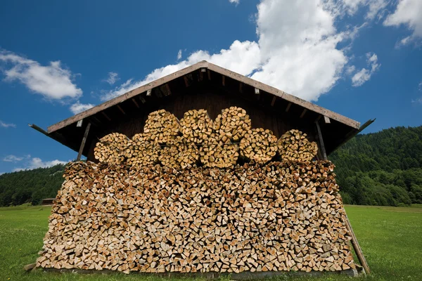Stacked firewood in front of log cabin — Stock Photo, Image