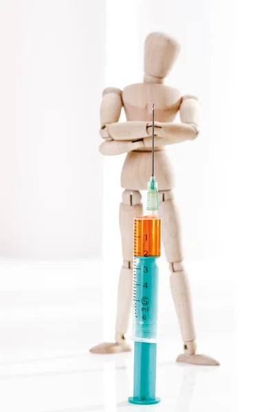 Wooden figurine and syringe — Stock fotografie