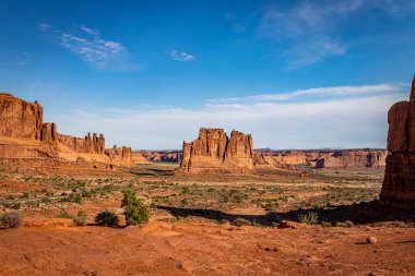 Kum taşı oluşumları, kemerler, doğal köprüler, pencereler ve tepeler dahil olmak üzere Moab, Utah yakınlarındaki Arches Ulusal Parkı 'nda hakim konumdadır..