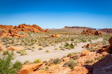 Ateş Eyaleti Parkı Clark County, Nevada 'da yer almaktadır ve 40.000 dönümden fazla açık kırmızı kumtaşı arazisi gri ve bronz kireç taşı yatakları ile çarpıcı bir tezat oluşturmaktadır..