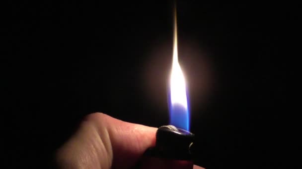 Удар запальничку, щоб запалити вогонь у темному полум'ї — стокове відео