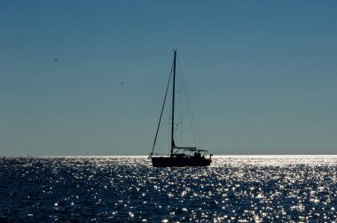 Arka planda yelkenli gemi