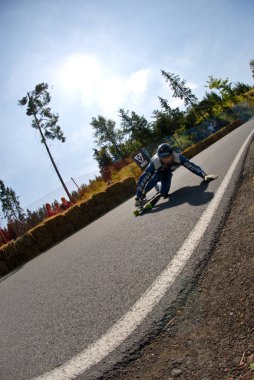 Siyah kasklı ve mavi ceketli bir adam yolda.