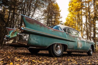 Yol kenarına park edilmiş klasik mavi bir araba..