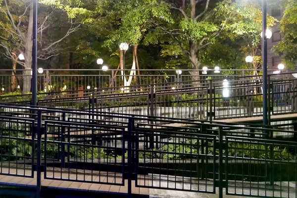 Gröna träd, trädgård gatlyktor i parken på kvällen — Stockfoto
