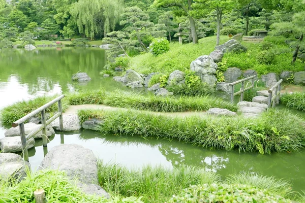 Pont en pierre avec cadres en bois, étang d'eau, herbes — Photo