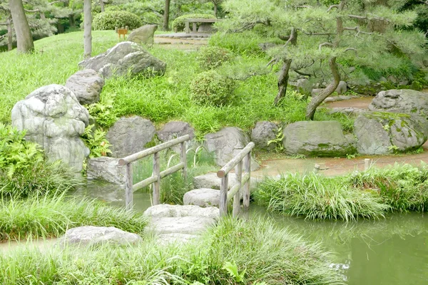 Pont en pierre avec cadres en bois, étang d'eau — Photo