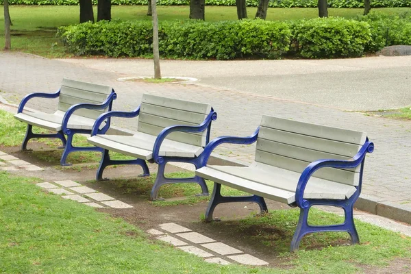 Wooden benches with blue arm bands in public park