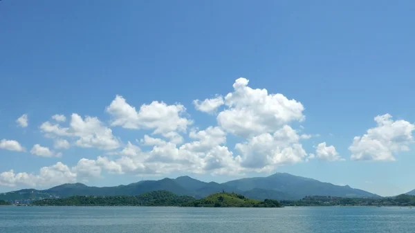 緑の山、湖、青い空と白い雲 — ストック写真