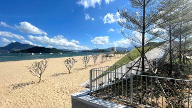 Hayat rehberi istasyonu, ağaç, bulutlar ve okyanus suyuyla geniş doğal fotoğraf.