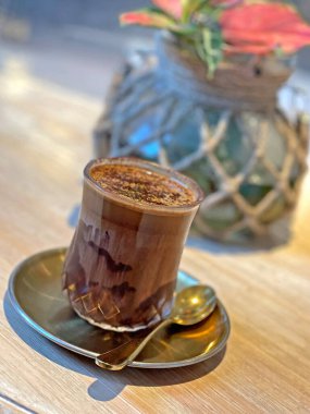 Zarif altın çanak ve ahşap masa üzerine bitki süslemeli soğuk, kirli kahve fincanı.