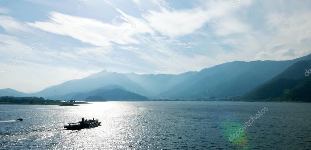 boat, ocean, mountains, and clouds