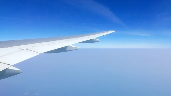 Flugzeugflügel, weiße Wolken und blauer Himmel — Stockfoto