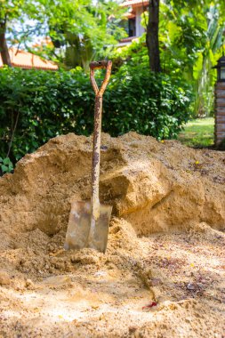 Eski paslı kürek ile şantiye kum yığını