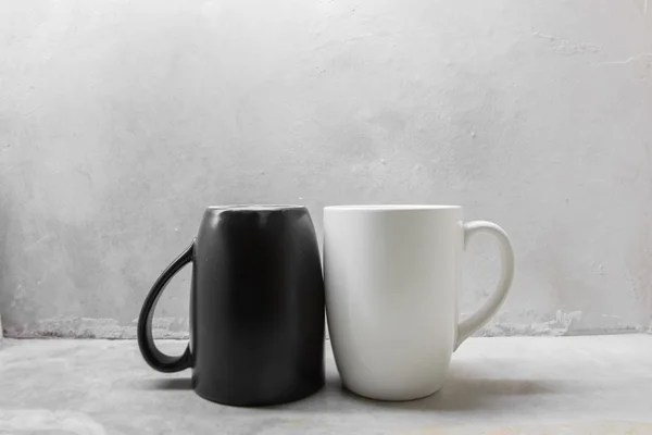 Black and white coffee mug on concrete table — Stock Photo, Image